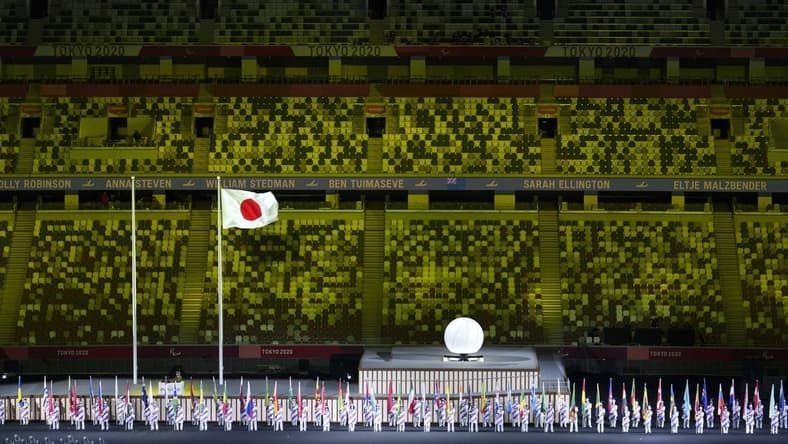 Aug 24, 2021; Tokyo, Japan; Athlete's Parade Assistants holding flags of the competing countries in front of the Protocol Stage during the Athlete's Parade at the Opening Ceremony of the Tokyo 2020 Paralympic Games. Mandatory Credit: Bob Martin/OIS Handout Photo via USA TODAY Sports