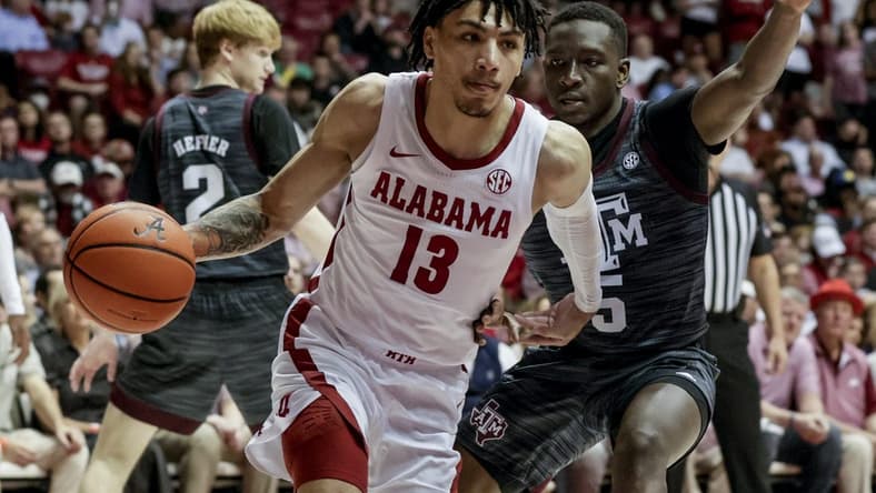 Mar 2, 2022; Tuscaloosa, Alabama, USA; Alabama Crimson Tide guard Jahvon Quinerly (13) drives the baseline around Texas A&M Aggies guard Hassan Diarra (5) during the second half at Coleman Coliseum. Mandatory Credit: Butch Dill-USA TODAY Sports