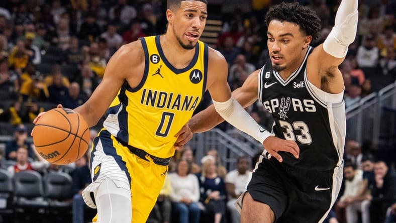 Oct 21, 2022; Indianapolis, Indiana, USA; Indiana Pacers guard Tyrese Haliburton (0) dribbles the ball while San Antonio Spurs guard Tre Jones (33) defends  in the second half at Gainbridge Fieldhouse. Mandatory Credit: Trevor Ruszkowski-USA TODAY Sports