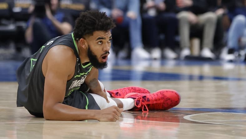 Nov 28, 2022; Washington, District of Columbia, USA; Minnesota Timberwolves center Karl-Anthony Towns (32) holds his leg after being injured against the Washington Wizards in the third quarter at Capital One Arena. Mandatory Credit: Geoff Burke-USA TODAY Sports
