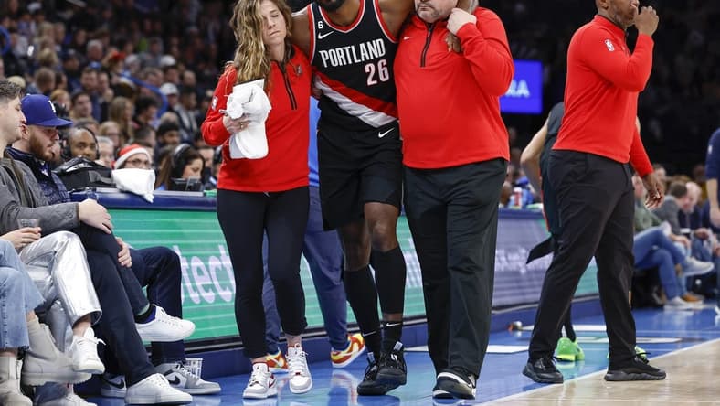 Dec 21, 2022; Oklahoma City, Oklahoma, USA; Portland Trail Blazers forward Justise Winslow (26) is helped off the court after a leg injury during the second half against the Oklahoma City Thunder at Paycom Center. Oklahoma City won 101-98. Mandatory Credit: Alonzo Adams-USA TODAY Sports