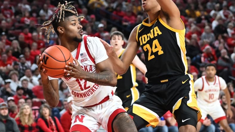 Dec 29, 2022; Lincoln, Nebraska, USA; Nebraska Cornhuskers guard Denim Dawson (12) attempts a shot against Iowa Hawkeyes forward Kris Murray (24) in the first half at Pinnacle Bank Arena. Mandatory Credit: Steven Branscombe-USA TODAY Sports