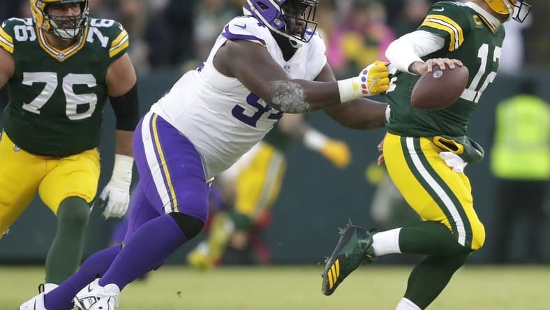 Jan 1, 2023; Green Bay, Wisconsin, USA; Minnesota Vikings defensive tackle Dalvin Tomlinson (94) pressures Green Bay Packers quarterback Aaron Rodgers (12) causing a fumble during their football at Lambeau Field. Mandatory Credit: Wm. Glasheen-USA TODAY Sports
