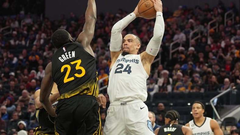 Dec 25, 2022; San Francisco, California, USA; Memphis Grizzlies forward Dillon Brooks (24) handles the ball against Golden State Warriors forward Draymond Green (23) during the fourth quarter at Chase Center. Mandatory Credit: Darren Yamashita-USA TODAY Sports