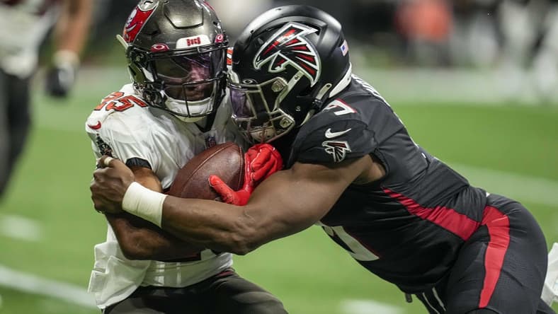 Jan 8, 2023; Atlanta, Georgia, USA; Tampa Bay Buccaneers running back Giovani Bernard (25) is tackled by Atlanta Falcons linebacker Lorenzo Carter (9) during the second half at Mercedes-Benz Stadium. Mandatory Credit: Dale Zanine-USA TODAY Sports