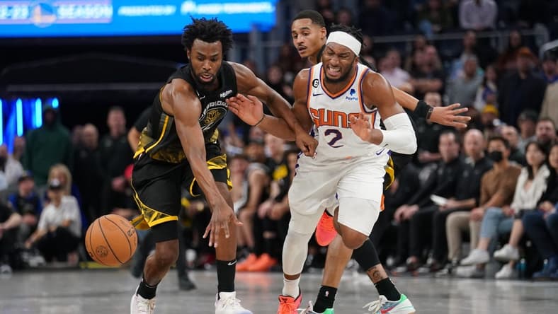 Jan 10, 2023; San Francisco, California, USA; Golden State Warriors forward Andrew Wiggins (22) knocks the ball out of the hands of Phoenix Suns guard Josh Okogie (2) in the fourth quarter at the Chase Center. Mandatory Credit: Cary Edmondson-USA TODAY Sports