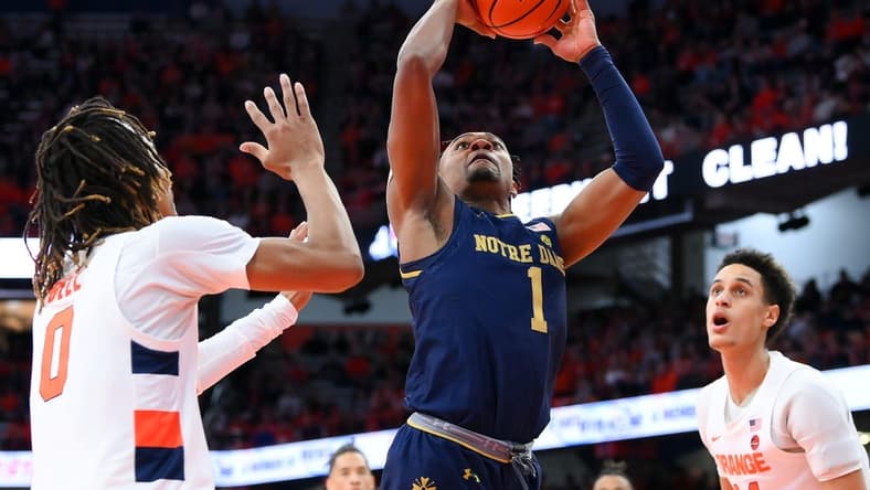 Jan 14, 2023; Syracuse, New York, USA; Notre Dame Fighting Irish guard J.J. Starling (1) drives to the basket between Syracuse Orange forward Chris Bell (0) and center Jesse Edwards (right) during the second half at the JMA Wireless Dome. Mandatory Credit: Rich Barnes-USA TODAY Sports