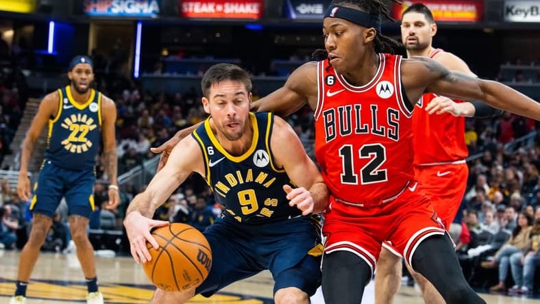 Jan 24, 2023; Indianapolis, Indiana, USA; Indiana Pacers guard T.J. McConnell (9) dribbles the ball while Chicago Bulls guard Ayo Dosunmu (12) defends in the second quarter at Gainbridge Fieldhouse. Mandatory Credit: Trevor Ruszkowski-USA TODAY Sports
