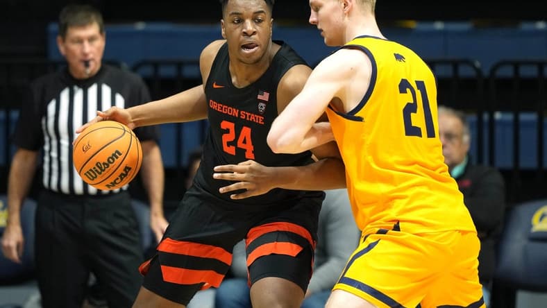 Jan 22, 2023; Berkeley, California, USA; Oregon State Beavers center KC Ibekwe (24) dribbles against California Golden Bears forward Lars Thiemann (21) during the second half at Haas Pavilion. Mandatory Credit: Darren Yamashita-USA TODAY Sports