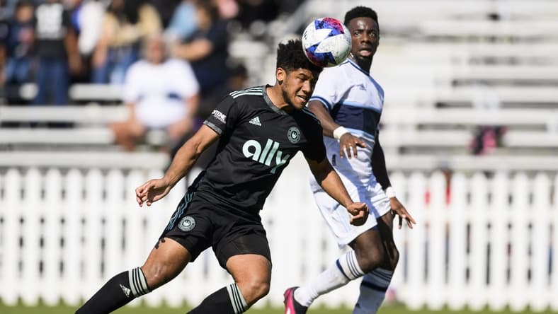 Feb 4, 2023; Indio, CA, USA; Charlotte FC Jaylin Lindsey (24) heads the ball away from Vancouver Whitecaps FC Cristian Dajome (11) at Empire Polo Club. Mandatory Credit: Kelvin Kuo-USA TODAY Sports