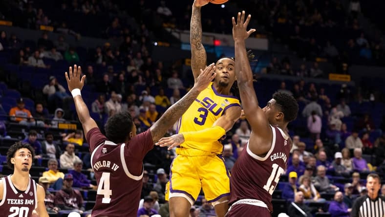 Feb 11, 2023; Baton Rouge, Louisiana, USA; LSU Tigers guard Justice Hill (3) passes the ball against Texas A&M Aggies forward Henry Coleman III (15) and guard Erik Pratt (3) during the first half at Pete Maravich Assembly Center. Mandatory Credit: Stephen Lew-USA TODAY Sports