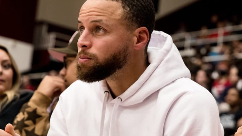 Feb 17, 2023; Stanford, California, USA;  Golden State Warriors guard Stephen Curry watches the game between the Stanford Cardinal and the USC Trojans during the second half at Maples Pavilion. Mandatory Credit: John Hefti-USA TODAY Sports