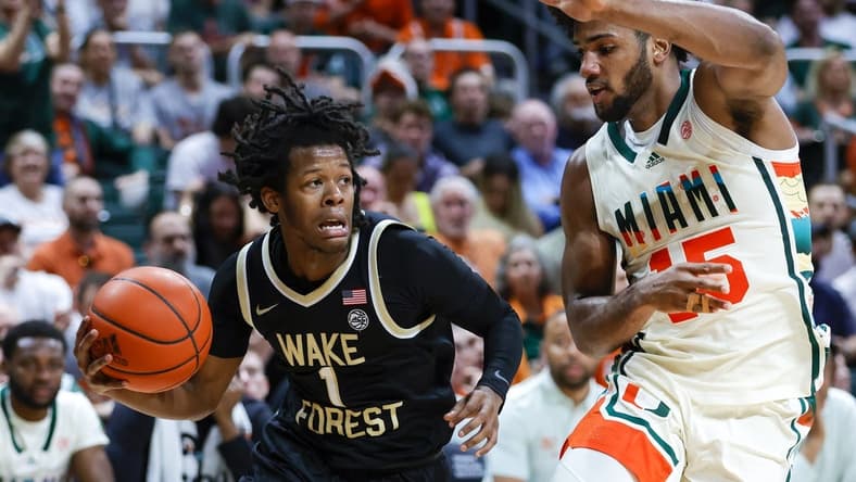 Feb 18, 2023; Coral Gables, Florida, USA; Wake Forest Demon Deacons guard Tyree Appleby (1) drives to the basket against Miami Hurricanes forward Norchad Omier (15) during the first half at Watsco Center. Mandatory Credit: Sam Navarro-USA TODAY Sports