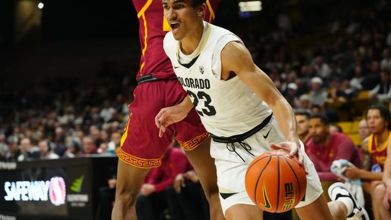 Feb 23, 2023; Boulder, Colorado, USA; Colorado Buffaloes forward Tristan da Silva (23) dribbles around USC Trojans forward Joshua Morgan (24) in the first half at the CU Events Center. Mandatory Credit: Ron Chenoy-USA TODAY Sports