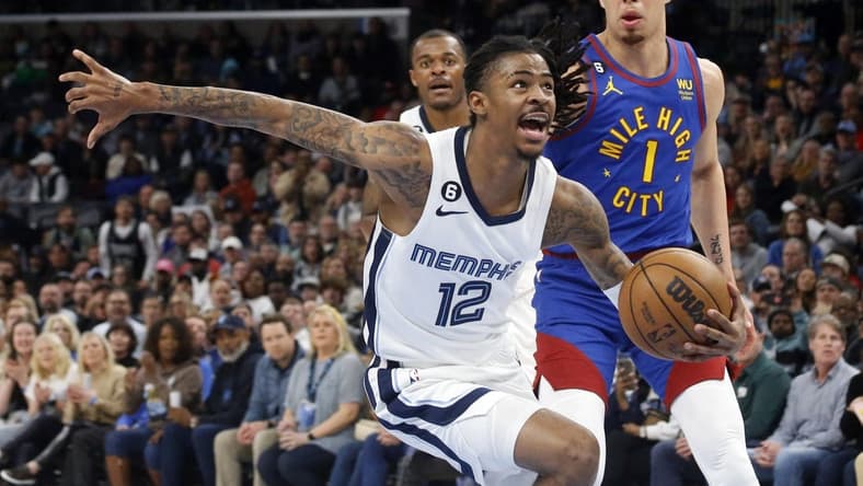 Feb 25, 2023; Memphis, Tennessee, USA; Memphis Grizzlies guard Ja Morant (12) drives to the basket as Denver Nuggets forward Michael Porter Jr. (1) defends during the second half at FedExForum. Mandatory Credit: Petre Thomas-USA TODAY Sports