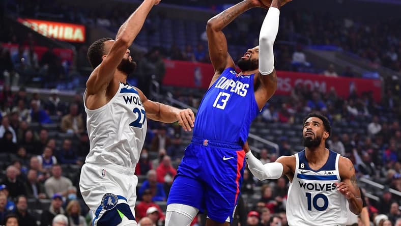 Feb 28, 2023; Los Angeles, California, USA; Los Angeles Clippers forward Paul George (13) shoots against Minnesota Timberwolves center Rudy Gobert (27) and guard Mike Conley (10) during the first half at Crypto.com Arena. Mandatory Credit: Gary A. Vasquez-USA TODAY Sports
