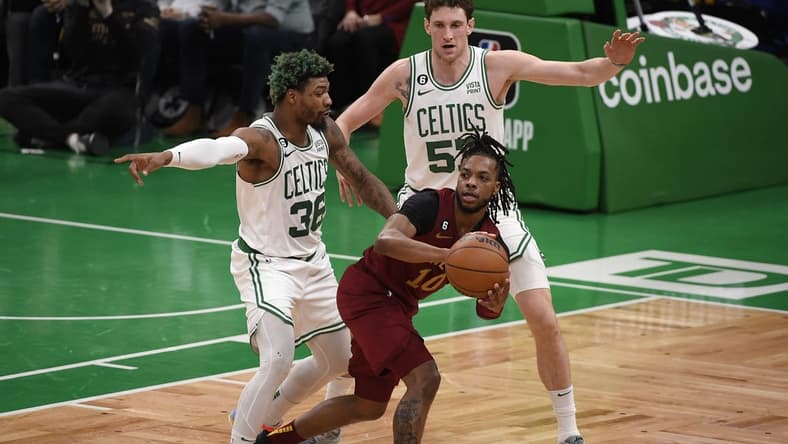 Mar 1, 2023; Boston, Massachusetts, USA;  Cleveland Cavaliers guard Darius Garland (10) controls the ball while Boston Celtics guard Marcus Smart (36) and forward Mike Mascala (57) defend during the first half at TD Garden. Mandatory Credit: Bob DeChiara-USA TODAY Sports