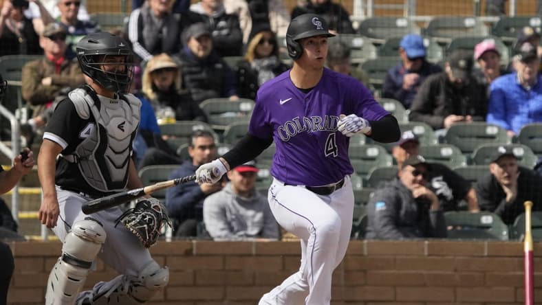 Mar 2, 2023; Salt River Pima-Maricopa, Arizona, USA; Colorado Rockies first baseman Michael Toglia (4) hits an RBI single against the Chicago White Sox in the third inning at Salt River Fields at Talking Stick. Mandatory Credit: Rick Scuteri-USA TODAY Sports