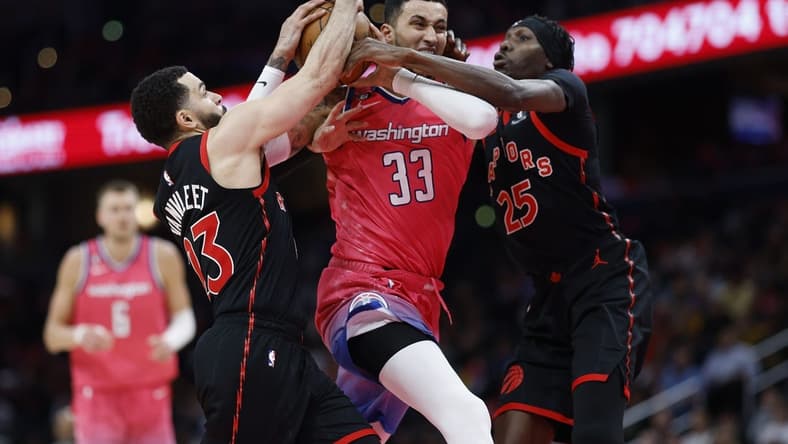 Mar 2, 2023; Washington, District of Columbia, USA; Washington Wizards forward Kyle Kuzma (33) drives to the basket as Toronto Raptors guard Fred VanVleet (23) and Raptors forward Chris Boucher (25) defend in the fourth quarter at Capital One Arena. Mandatory Credit: Geoff Burke-USA TODAY Sports