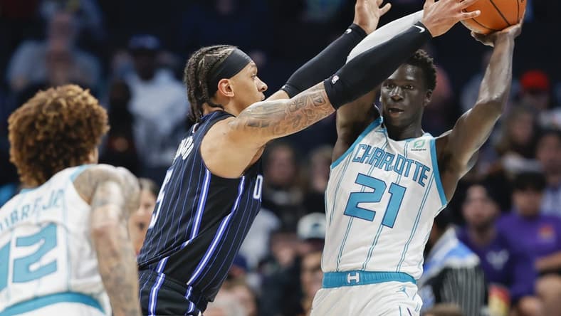 Mar 3, 2023; Charlotte, North Carolina, USA; Charlotte Hornets forward JT Thor (21) tries to pass against Orlando Magic forward Paolo Banchero (5) during the first half at Spectrum Center. Mandatory Credit: Nell Redmond-USA TODAY Sports