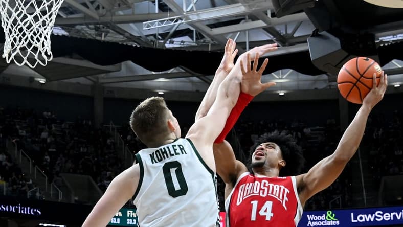Mar 4, 2023; East Lansing, Michigan, USA;  Ohio State Buckeyes forward Justice Sueing (14) shoots against Michigan State Spartans forward Jaxon Kohler (0) in the first half at Jack Breslin Student Events Center. Mandatory Credit: Dale Young-USA TODAY Sports