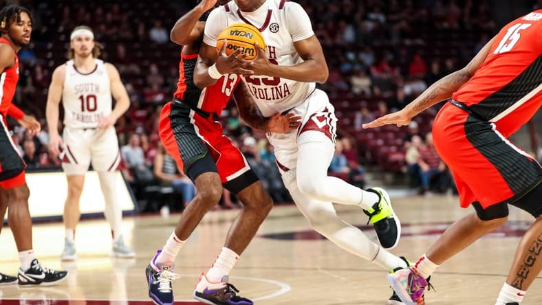Mar 4, 2023; Columbia, South Carolina, USA; South Carolina Gamecocks forward Gregory Jackson II (23) drives around Georgia Bulldogs guard Mardrez McBride (13) in the first half at Colonial Life Arena. Mandatory Credit: Jeff Blake-USA TODAY Sports