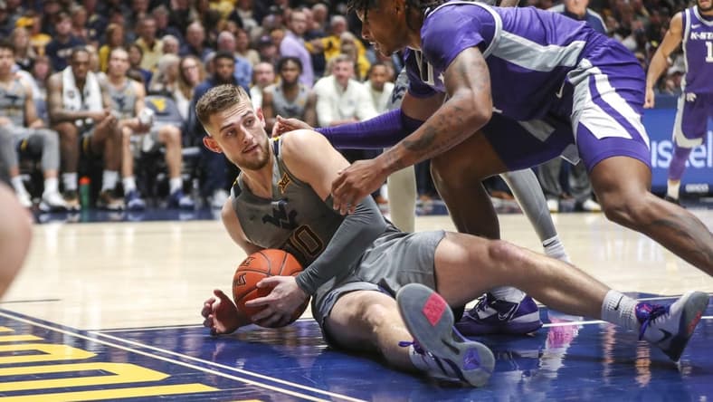 Mar 4, 2023; Morgantown, West Virginia, USA; West Virginia Mountaineers guard Erik Stevenson (10) dives for the ball while defended by Kansas State Wildcats guard Tykei Greene (4) during the first half at WVU Coliseum. Mandatory Credit: Ben Queen-USA TODAY Sports