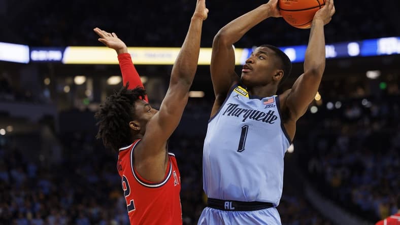 Mar 4, 2023; Milwaukee, Wisconsin, USA;  Marquette Golden Eagles guard Kam Jones (1) shoots against St. John   s Red Storm guard Kolby King (12) during the second half at Fiserv Forum. Mandatory Credit: Jeff Hanisch-USA TODAY Sports