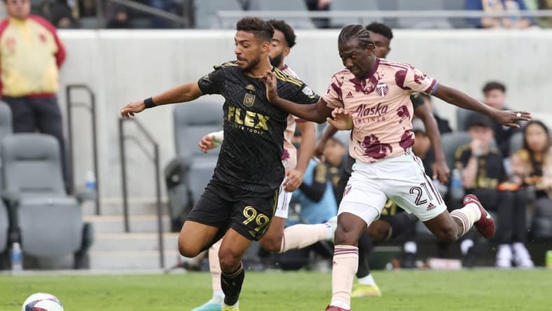 Mar 4, 2023; Los Angeles, California, USA; Los Angeles FC forward Denis Bouanga (99) dribbles against Portland Timbers midfielder Diego Chara (21) during the first half at BMO Stadium. Mandatory Credit: Jason Parkhurst-USA TODAY Sports