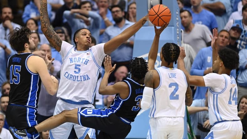 Mar 4, 2023; Chapel Hill, North Carolina, USA; Duke Blue Devils guard Jeremy Roach (3) shoots as North Carolina Tar Heels forward Armando Bacot (5) and guard Caleb Love (2) and forward Puff Johnson (14) defend in the second half at Dean E. Smith Center. Mandatory Credit: Bob Donnan-USA TODAY Sports
