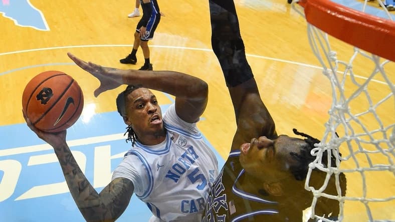 Mar 4, 2023; Chapel Hill, North Carolina, USA; North Carolina Tar Heels forward Armando Bacot (5) shoots as Duke Blue Devils forward Mark Mitchell (25) defends in the second half at Dean E. Smith Center. Mandatory Credit: Bob Donnan-USA TODAY Sports