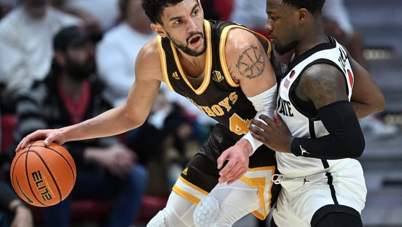 Mar 4, 2023; San Diego, California, USA; Wyoming Cowboys guard Hunter Maldonado (24) dribbles the ball while defended by San Diego State Aztecs guard Darrion Trammell (12) during the first half at Viejas Arena. Mandatory Credit: Orlando Ramirez-USA TODAY Sports