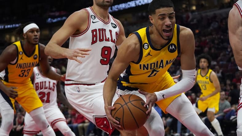 Mar 5, 2023; Chicago, Illinois, USA; Chicago Bulls center Nikola Vucevic (9) defends Indiana Pacers guard Tyrese Haliburton (0) during the first quarter at United Center. Mandatory Credit: David Banks-USA TODAY Sports