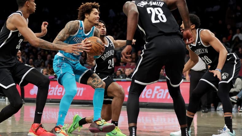 Mar 5, 2023; Brooklyn, New York, USA; Charlotte Hornets guard Kelly Oubre Jr. (12) drives to the basket against Brooklyn Nets center Nic Claxton (33) and guard Cam Thomas (24) and forward Dorian Finney-Smith (28) and guard Spencer Dinwiddie (26) during the second quarter at Barclays Center. Mandatory Credit: Brad Penner-USA TODAY Sports