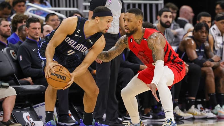 Mar 5, 2023; Orlando, Florida, USA; Portland Trail Blazers guard Damian Lillard (0) defends Orlando Magic guard Jalen Suggs (4) during the second quarter at Amway Center. Mandatory Credit: Mike Watters-USA TODAY Sports