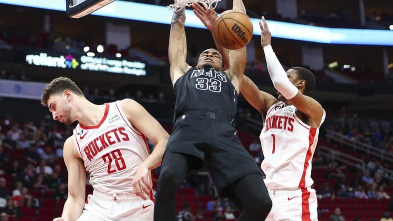 Mar 7, 2023; Houston, Texas, USA; Brooklyn Nets center Nic Claxton (33) dunks the ball as Houston Rockets center Alperen Sengun (28) and forward Jabari Smith Jr. (1) defend during the third quarter at Toyota Center. Mandatory Credit: Troy Taormina-USA TODAY Sports