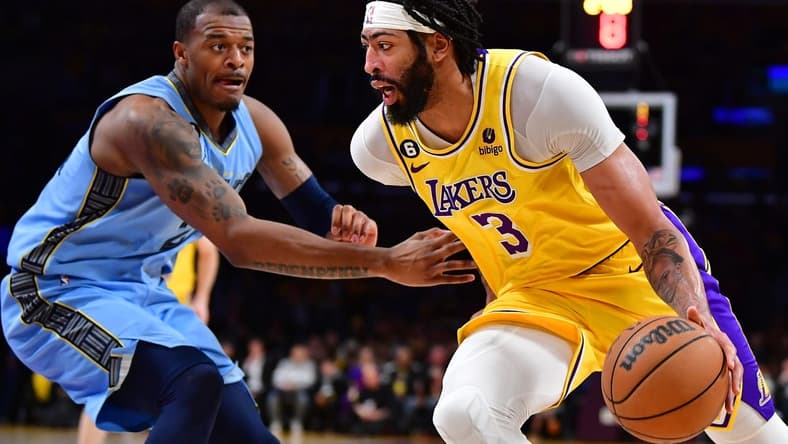Mar 7, 2023; Los Angeles, California, USA; Los Angeles Lakers forward Anthony Davis (3) moves the ball against Memphis Grizzlies forward Xavier Tillman (2) during the first half at Crypto.com Arena. Mandatory Credit: Gary A. Vasquez-USA TODAY Sports