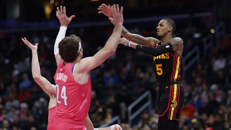 Mar 8, 2023; Washington, District of Columbia, USA; Atlanta Hawks guard Dejounte Murray (5) leaps to pass the ball over Washington Wizards forward Corey Kispert (24) in the first quarter at Capital One Arena. Mandatory Credit: Geoff Burke-USA TODAY Sports