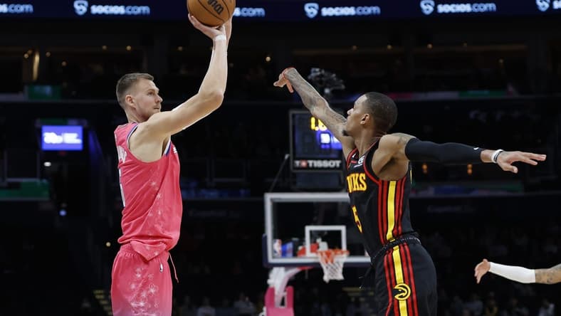 Mar 8, 2023; Washington, District of Columbia, USA; Washington Wizards center Kristaps Porzingis (6) shoots the ball as Atlanta Hawks guard Dejounte Murray (5) defends in the fourth quarter at Capital One Arena. Mandatory Credit: Geoff Burke-USA TODAY Sports