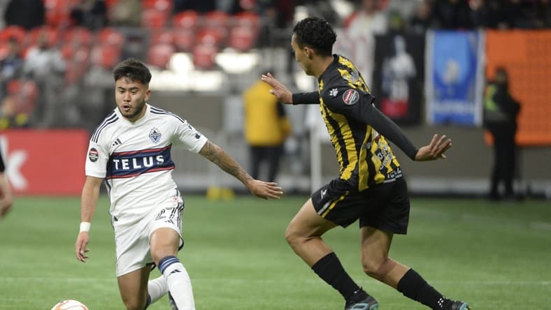 Mar 8, 2023; Vancouver, British Columbia, CAN; Vancouver Whitecaps FC midfielder Ryan Raposo (27) chases a loose ball against Real Espana defender Carlos Mejia (28) during the first half at BC Place Stadium. Mandatory Credit: Anne-Marie Sorvin-USA TODAY Sports