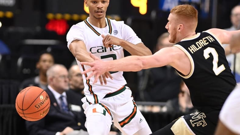 Mar 9, 2023; Greensboro, NC, USA; Miami (Fl) Hurricanes guard Isaiah Wong (2) passes the ball as Wake Forest Demon Deacons guard Cameron Hildreth (2) defends during the first half of the quarterfinals of the ACC tournament at Greensboro Coliseum. Mandatory Credit: Bob Donnan-USA TODAY Sports
