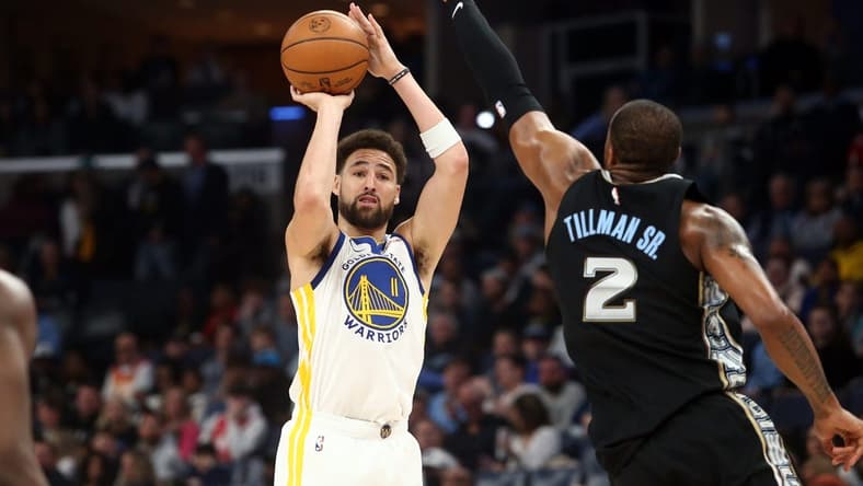 Mar 9, 2023; Memphis, Tennessee, USA; Golden State Warriors guard Klay Thompson (11) shoots for three as Memphis Grizzlies forward Xavier Tillman (2) defends during the first half at FedExForum. Mandatory Credit: Petre Thomas-USA TODAY Sports