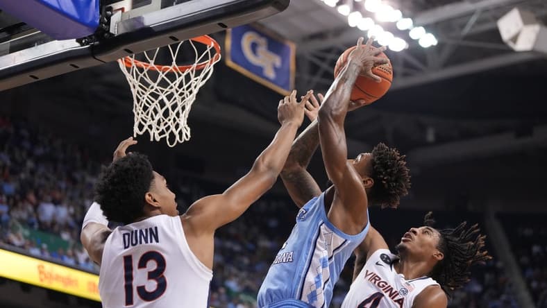 Mar 9, 2023; Greensboro, NC, USA; North Carolina Tar Heels forward Leaky Black (1) shoots as Virginia Cavaliers guard Ryan Dunn (13) and guard Armaan Franklin (4) defend in the first half of the quarterfinals of the ACC tournament at Greensboro Coliseum. Mandatory Credit: Bob Donnan-USA TODAY Sports