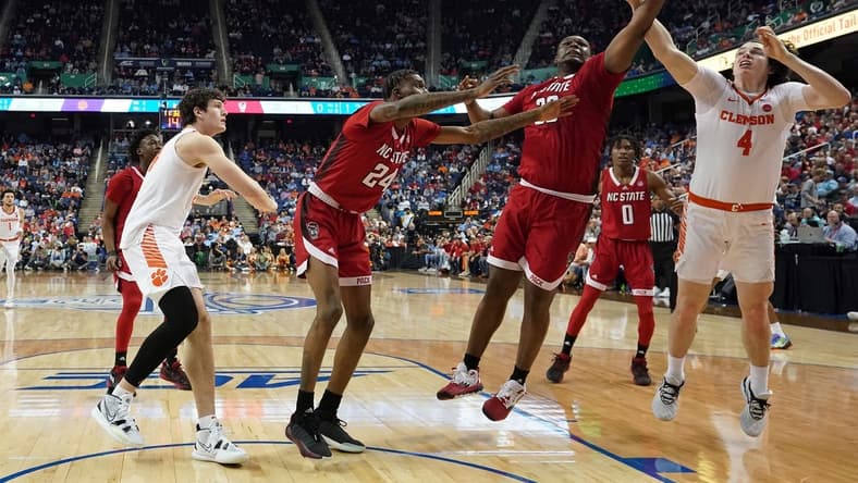 Mar 9, 2023; Greensboro, NC, USA; North Carolina State Wolfpack forward D.J. Burns Jr. (30) battles with Clemson Tigers forward Ian Schieffelin (4) for the ball during the first half of the quarterfinals of the ACC tournament at Greensboro Coliseum. Mandatory Credit: John David Mercer-USA TODAY Sports