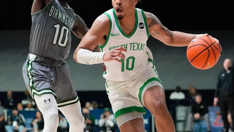 Mar 10, 2023; Frisco, TX, USA;  North Texas Mean Green guard Kai Huntsberry (10) drives to the basket past UAB Blazers guard Jordan Walker (10) during the second half at Ford Center at The Star. Mandatory Credit: Chris Jones-USA TODAY Sports