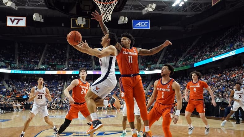 Mar 10, 2023; Greensboro, NC, USA; Virginia Cavaliers guard Kihei Clark (0) drives to the basket against Clemson Tigers guard Brevin Galloway (11) during the first half of the semifinals of the ACC tournament at Greensboro Coliseum. Mandatory Credit: John David Mercer-USA TODAY Sports