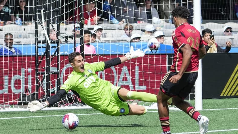 Mar 11, 2023; Charlotte, North Carolina, USA;  Atlanta United defender Caleb Wiley (26) shoots for a scoring goal against Charlotte FC goalkeeper Pablo Sisniega (23) during the first half at Bank of America Stadium. Mandatory Credit: Jim Dedmon-USA TODAY Sports