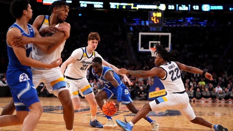 Mar 11, 2023; New York, NY, USA; Xavier Musketeers guard Souley Boum (0) drives as Marquette Golden Eagles forward Ben Gold (21) and Marquette Golden Eagles guard Sean Jones (22) defend in the first half at Madison Square Garden. Mandatory Credit: Kareem Elgazzar-USA TODAY Sports