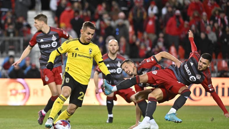 Mar 11, 2023; Toronto, Ontario, CAN;  Columbus Crew midfielder Alexandru Matan (20) controls the ball as Toronto FC defender Raoul Petretta (28) collides with a teammate in the first half at BMO Field. Mandatory Credit: Dan Hamilton-USA TODAY Sports