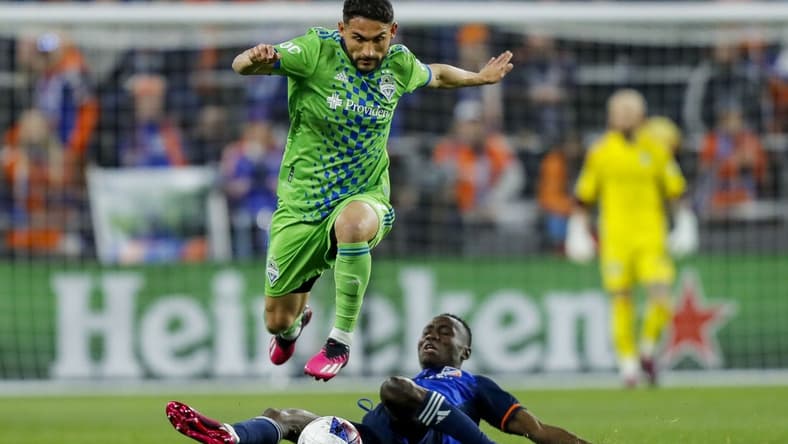Mar 11, 2023; Cincinnati, Ohio, USA; Seattle Sounders FC midfielder Cristian Roldan (7) dribbles against FC Cincinnati midfielder Obinna Nwobodo (5) in the first half at TQL Stadium. Mandatory Credit: Katie Stratman-USA TODAY Sports